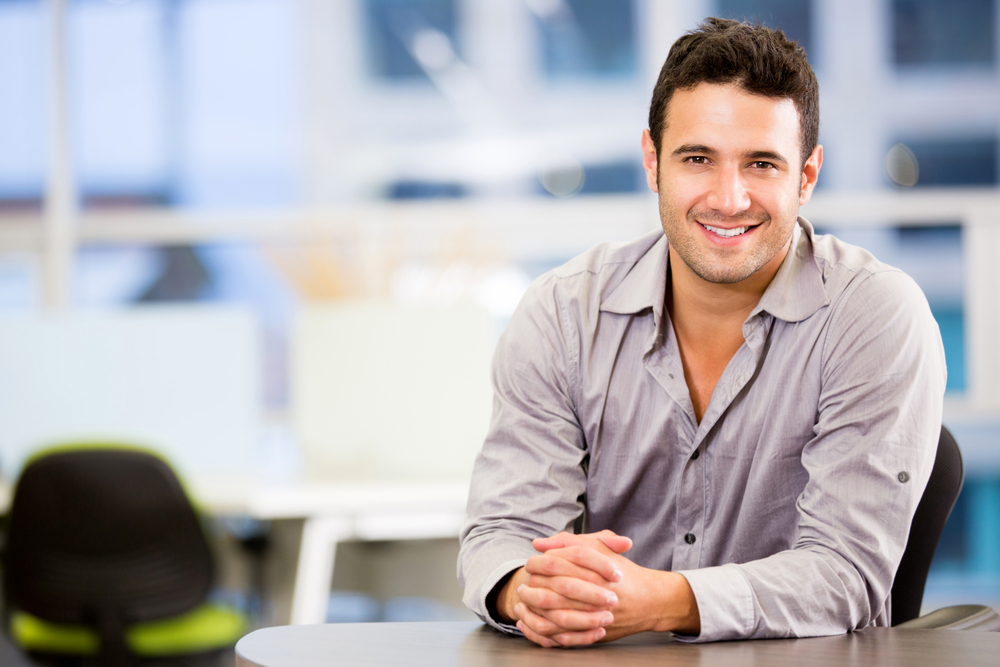 Young professional at desk and smiling